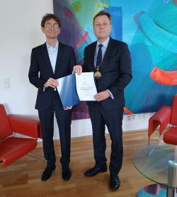 Der Präsident der Universität Potsdam, Prof. Oliver Günther, Ph.D. (rechts), bei der Übergabe der Ernennungsurkunde an Prof. Dr. Jonathan Pfaff (links).  © Universität Potsdam