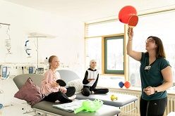 Sporttherapeutin Sabine Barde (r.) lenkt Lotta und Emily während ihrer Chemotherapie in der Tagesklinik der Kinderonkologie am Uniklinikum Dresden mit einem Ballspiel ab.  UKD/Kirsten Lassig